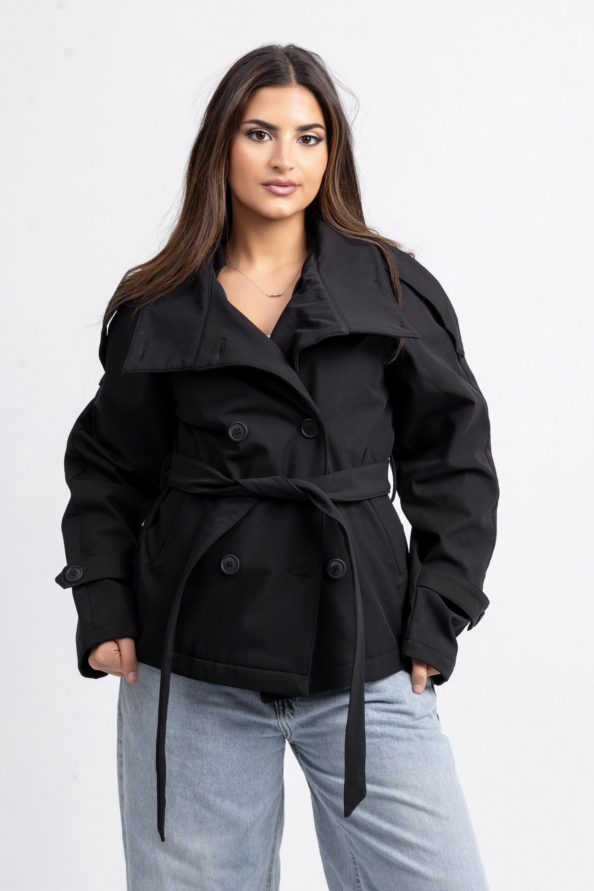 Woman wearing a black coat with a white background