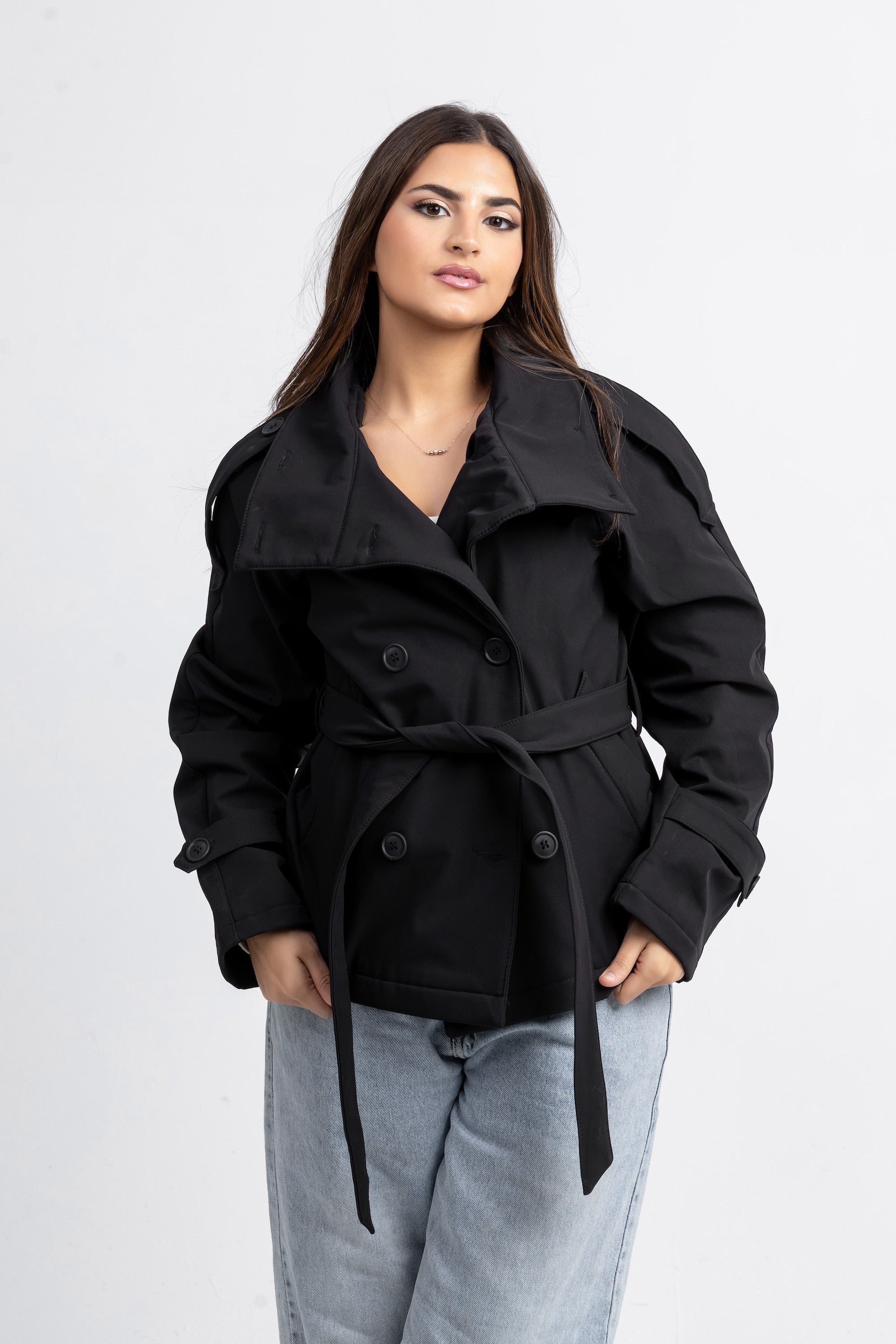 Woman wearing a black coat with a white background