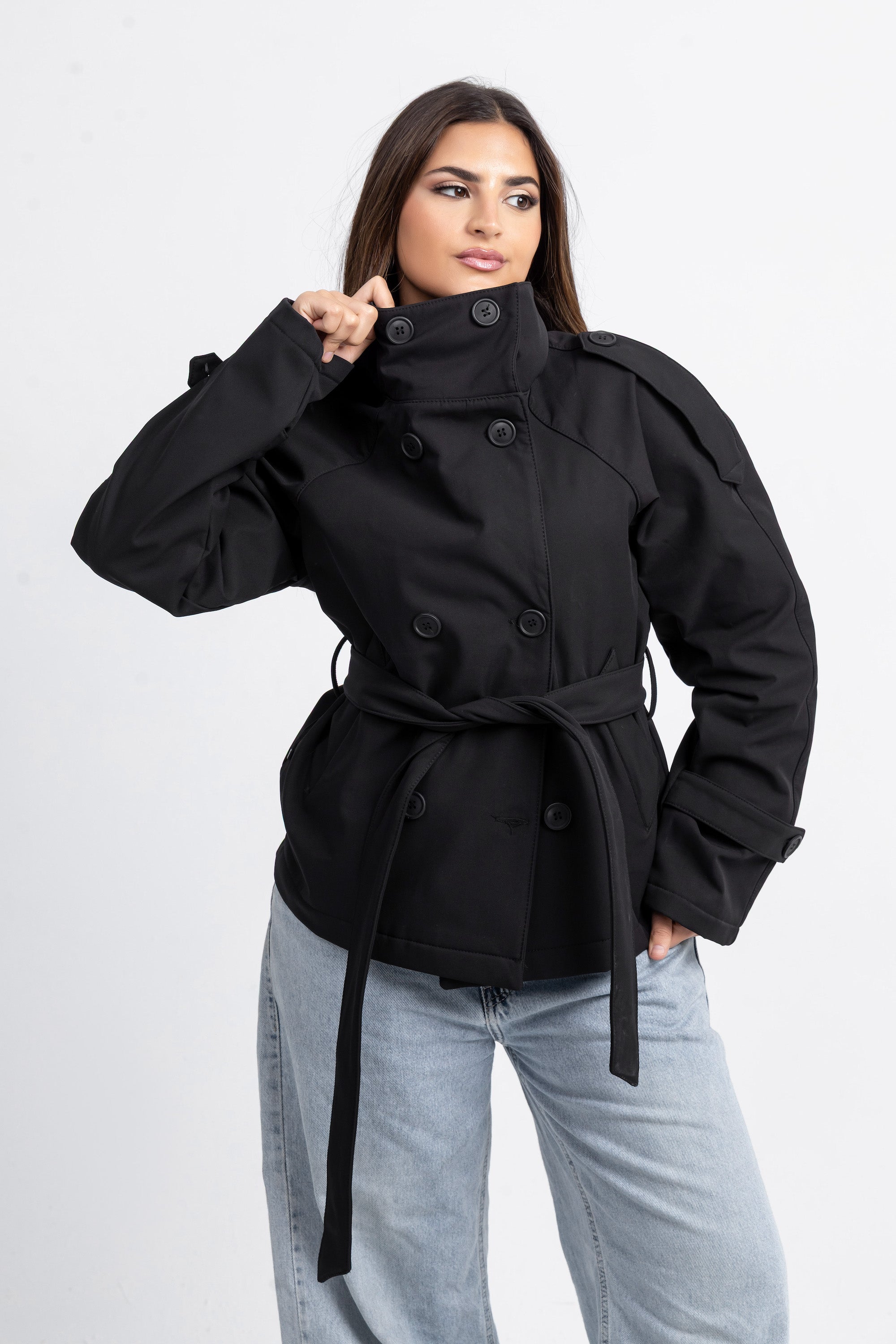 Woman wearing a black coat with a white background